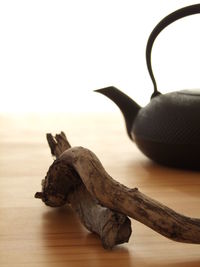 Close-up of wood and kettle on table