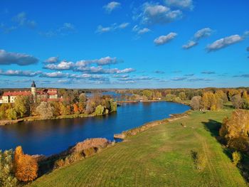 Scenic view of lake by buildings against blue sky