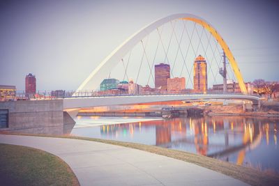 Bridge over river against sky at sunset