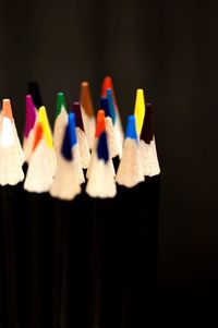 Close-up of colored pencils against black background