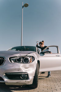 Man driving car against sky