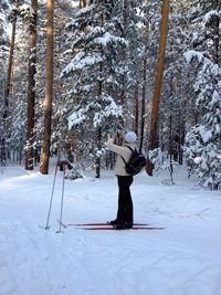 Full length of man skiing on snowy field against trees