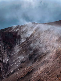 Smoke emitting from volcanic mountain against sky