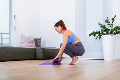 Side view of young woman exercising in gym