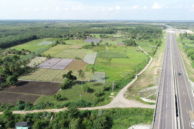 High angle view of road amidst field against sky