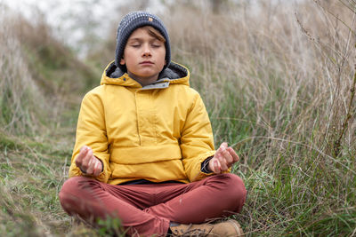Young man sitting on field