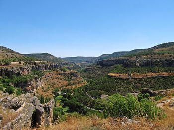 Scenic view of mountains and valley against clear blue sky