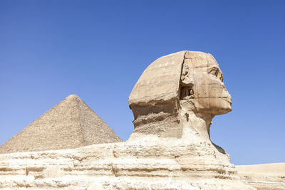 The sphinx and pyramid of mycerinus against clear blue sky