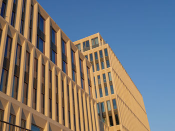 Low angle view of modern building against clear blue sky