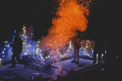 People working firework display at night