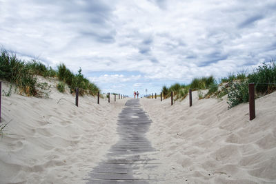 People walking on beach against sky