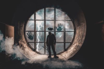 Digital composite image of man standing in glass window