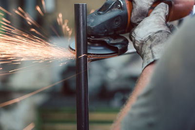 Midsection of man working on metal in workshop