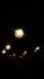 Low angle view of illuminated lights at night