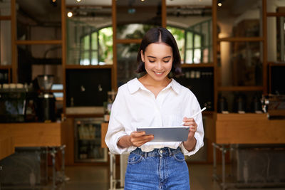 Portrait of young woman standing in store