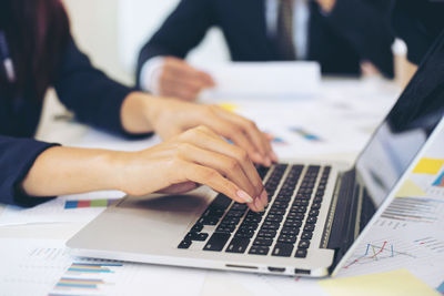 Midsection of woman using laptop on table