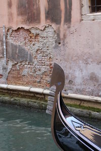 View of canal against wall, the edge of a classic venetian boat