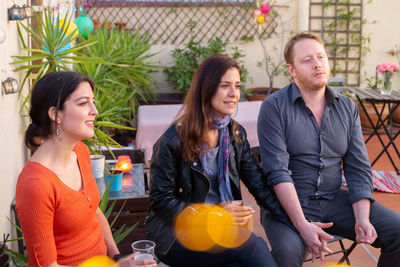 Friends with drinks sitting at outdoor restaurant