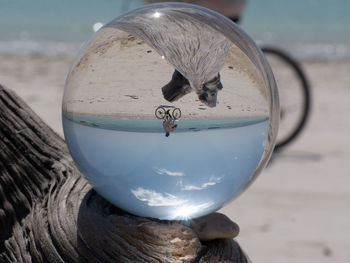 Close-up of crystal ball on beach