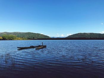 Scenic view of lake against clear blue sky