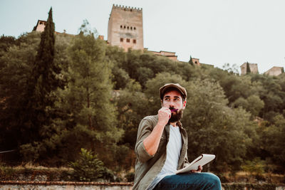 Man writing in book while sitting outdoors