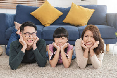 Portrait of smiling young woman sitting on sofa