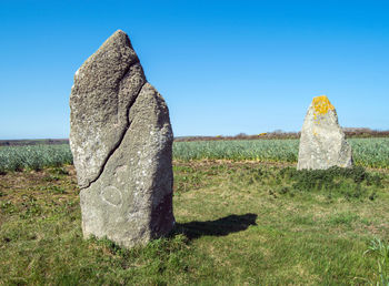 Stone wall on field against clear sky