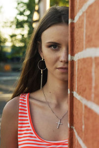 Portrait of woman by brick wall