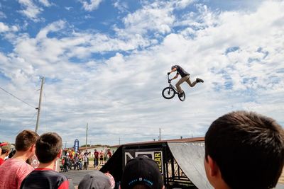 Rear view of people walking on motorcycle against sky