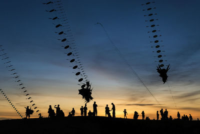Silhouette people against sky during sunset