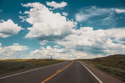 Empty road against cloudy sky