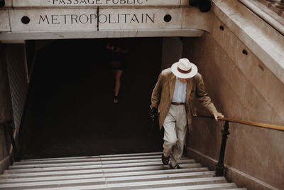 Rear view of man walking on staircase