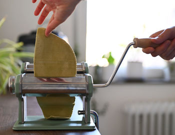 Cropped hands of person making noodles