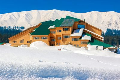 Houses on snowcapped mountain against sky