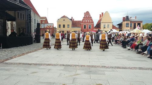 Group of people on street by buildings in city