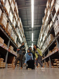 Low angle portrait of happy friends posing in warehouse