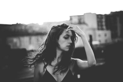 Portrait of woman looking at city against sky