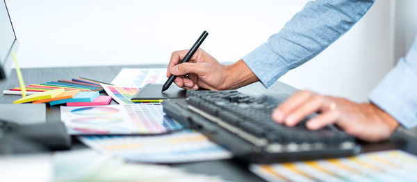 Midsection of businessman working on table