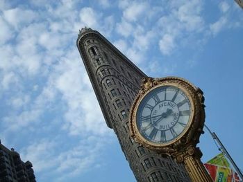 Low angle view of clock tower against cloudy sky