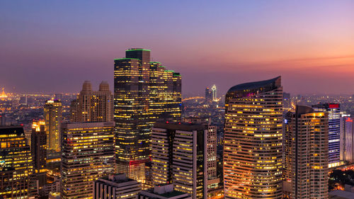 High angle view of city lit up at sunset