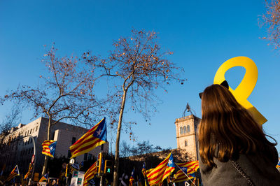 Rear view of woman against blue sky