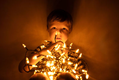 Full length of boy with illuminated lights at home