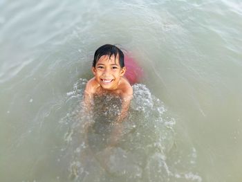 Portrait of smiling boy swimming in water