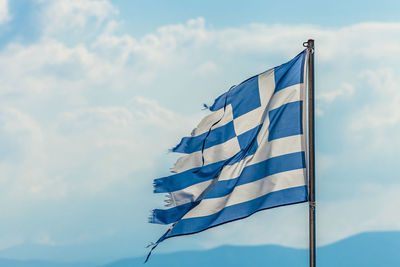 Low angle view of greek flag waving against sky