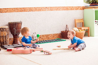 Cute boy playing with toy sitting outdoors