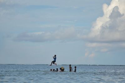 People on sea against sky