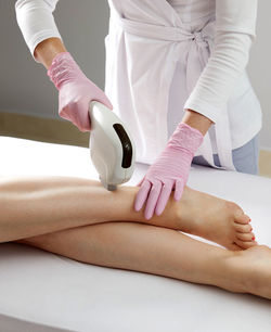 Laser hair removal on ladies legs in beauty salon