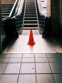 Traffic cone by escalator at subway station