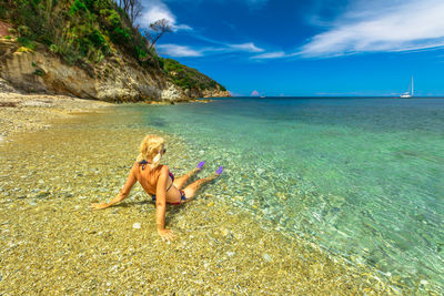 Woman with dog at beach against sky