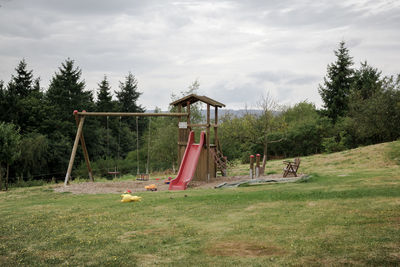 View of swing in park against cloudy sky